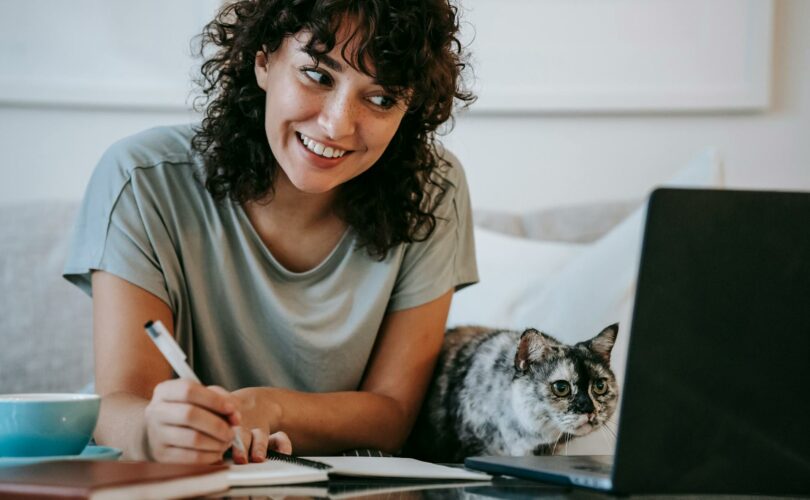 kobieta pracuję przy laptopie z kotem obok